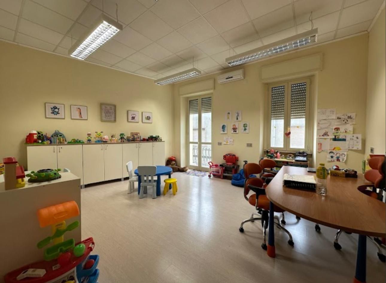 Spazio dello studio dedicato ai bambini, con giochi, tavolino e materiali per le attività